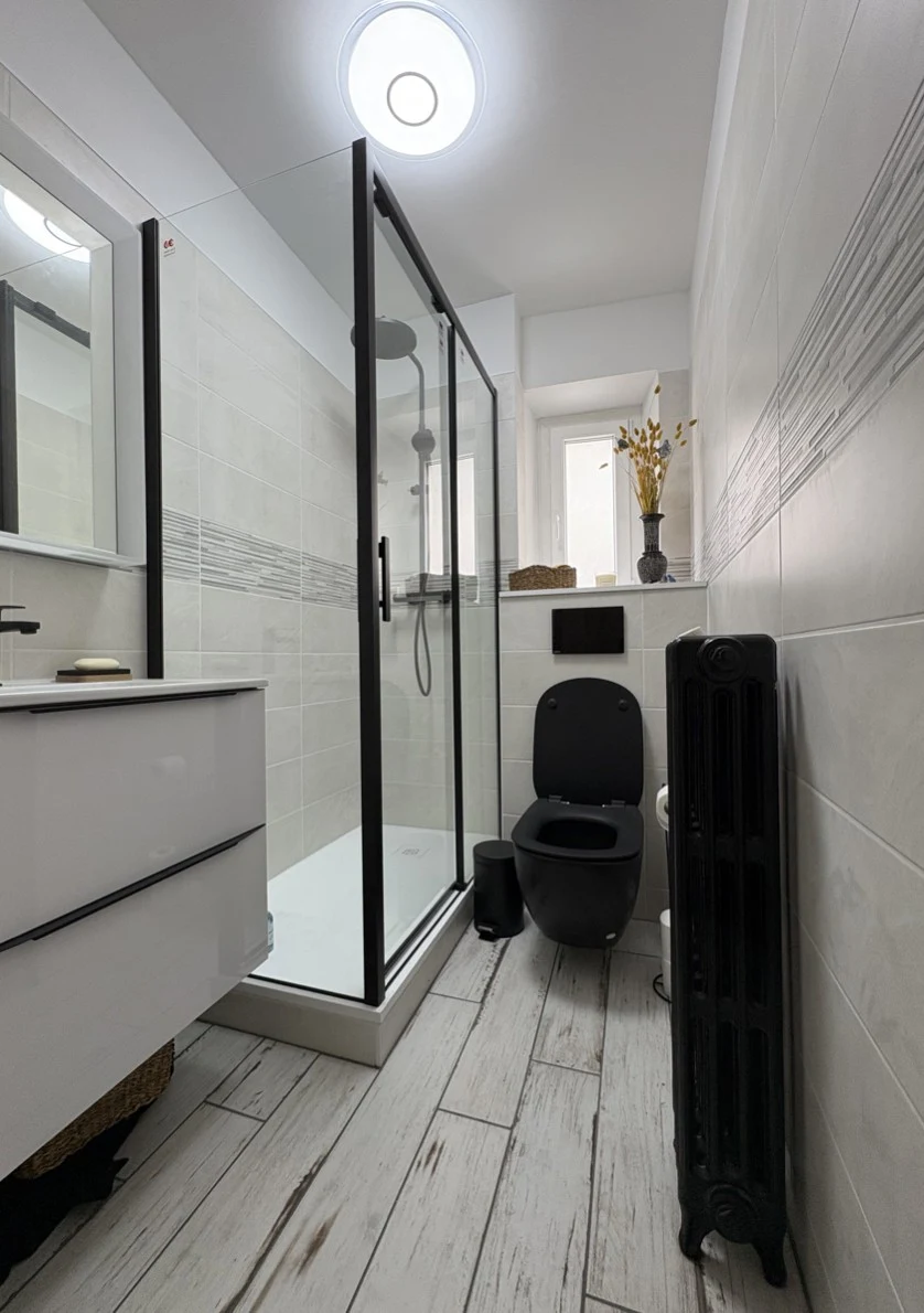 Salle de bain rénovée par Qualidro à Nantes : douche moderne, WC suspendus, meuble vasque contemporain et carrelage refait à neuf.